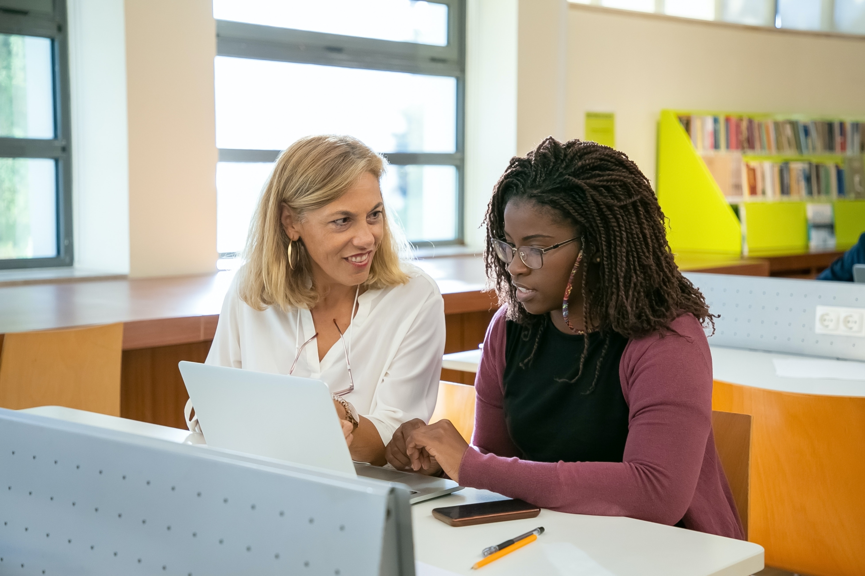 Teacher and Student talking in front of a laptop